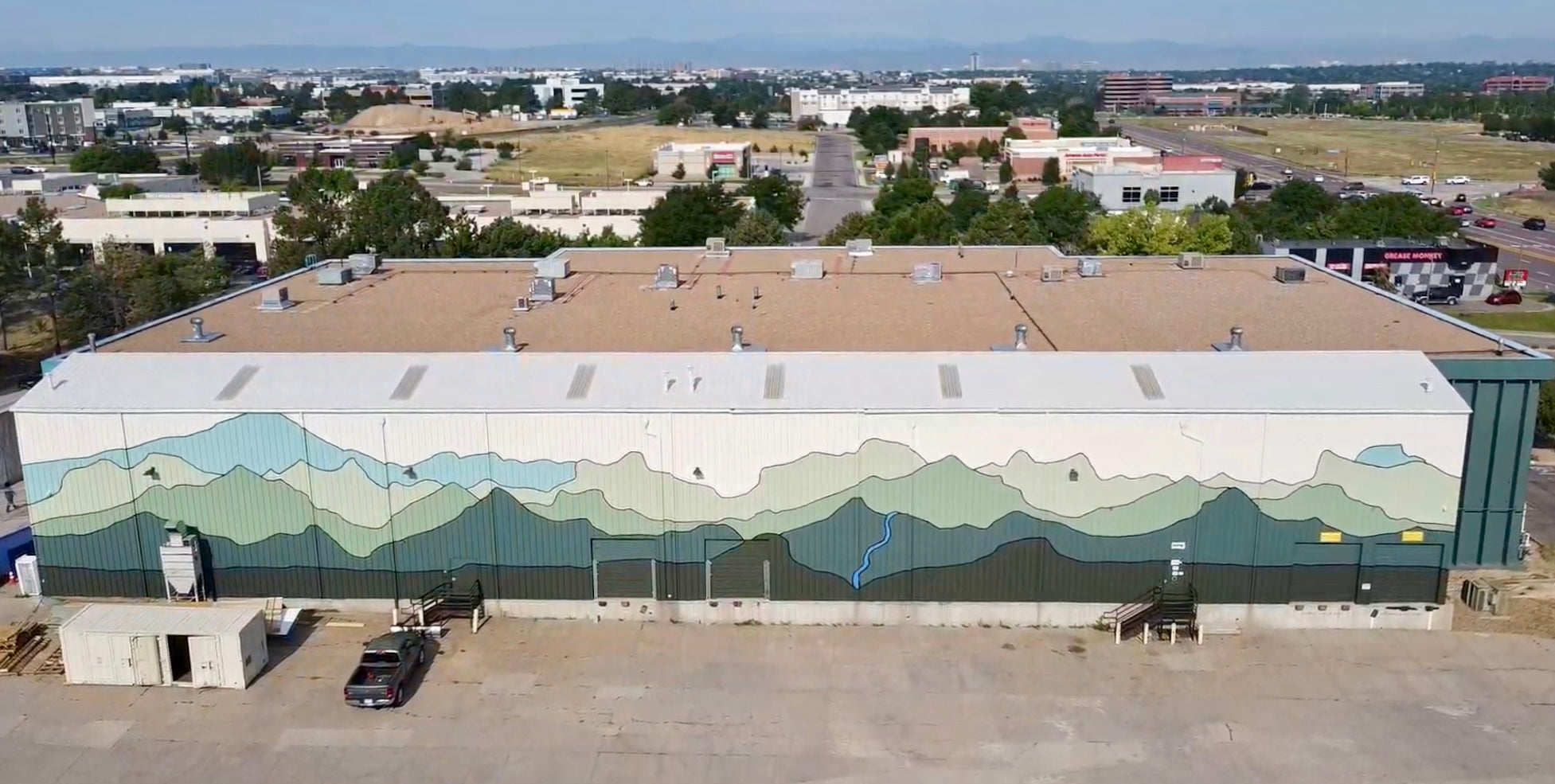 Minimalist mountain mural on a warehouse painted by DeeBee Whimzy for Aspendale Centennial