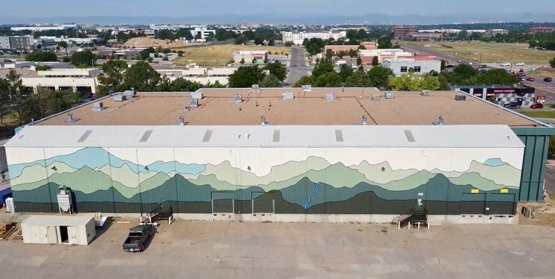 Minimalist mountain mural on a warehouse painted by DeeBee Whimzy for Aspendale Centennial